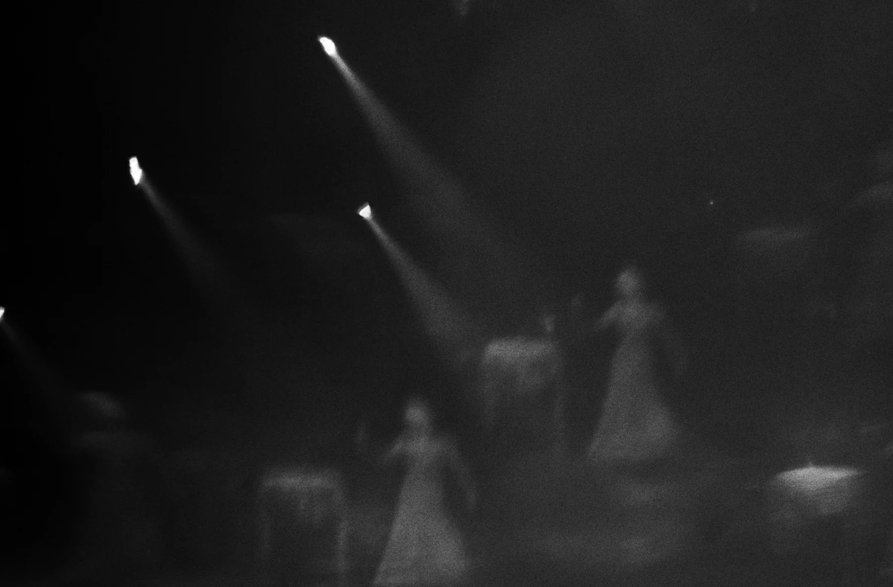 Performers moving through dramatic stage light